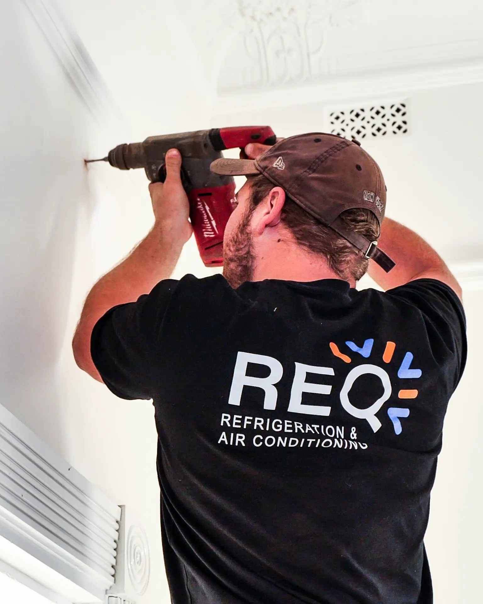 REQ Heating & Cooling technician servicing an HVAC unit