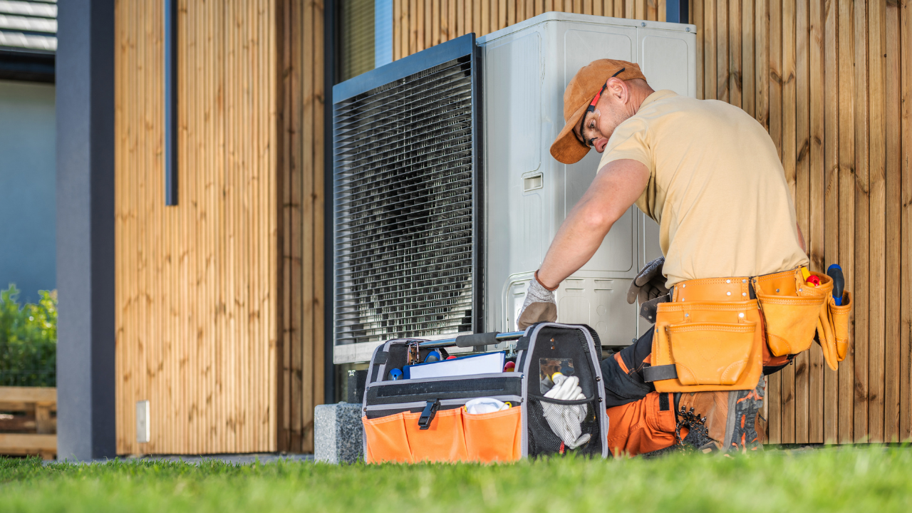 Technician working on an outdoor air conditioning unit